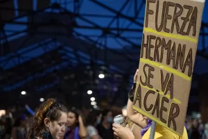 Foto de mujer sosteniendo un carte con el lema "Fuerza hermana se va a caer"